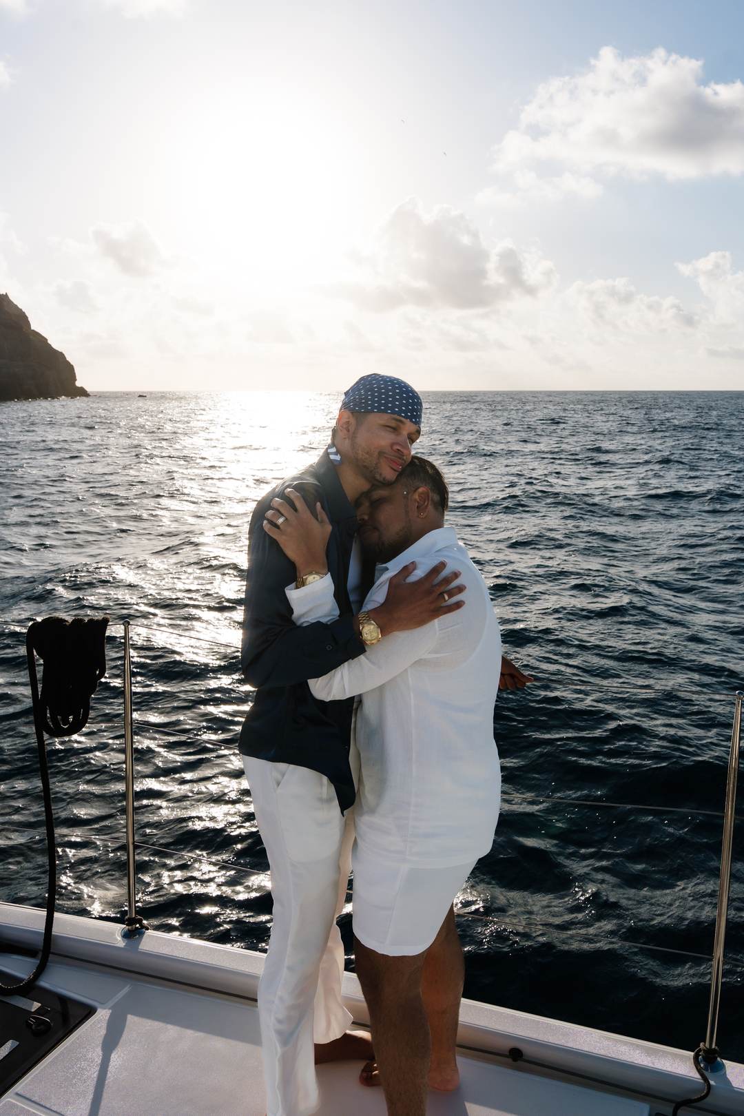 An embrace at the mast in the last gold of a caldera evening sail Sea