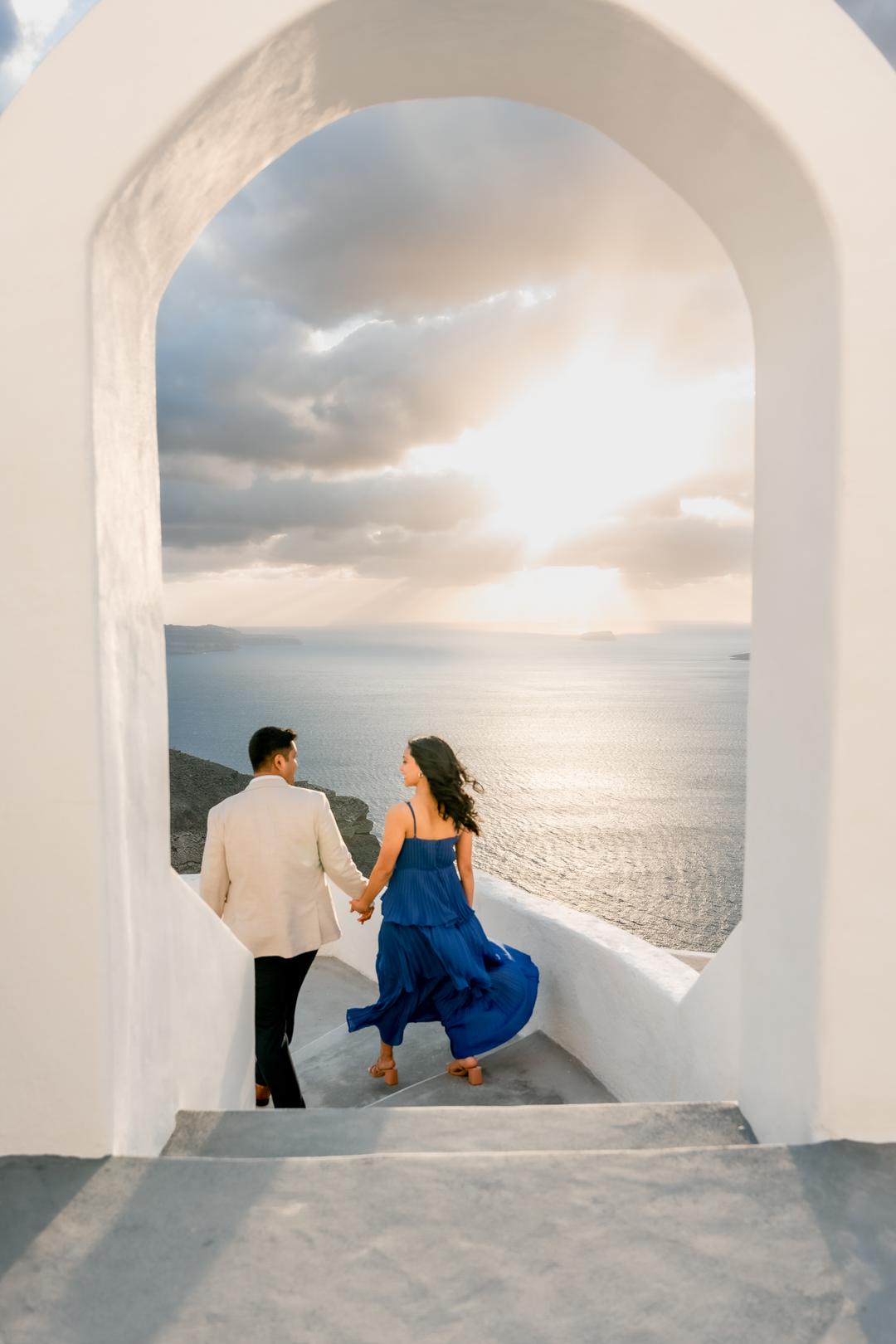 Dressed for the caldera: a couple descending whitewashed steps toward the open sea