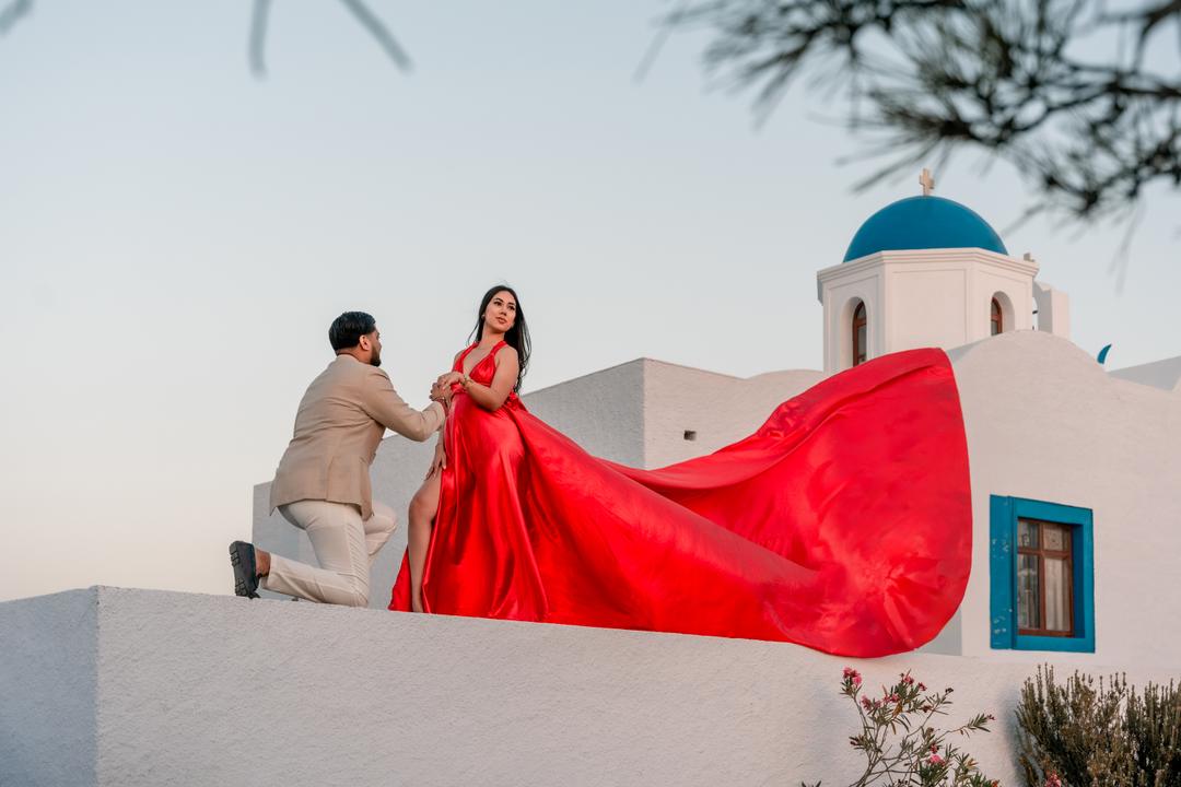 A red flying dress unfurled beside a blue-domed rim chapel