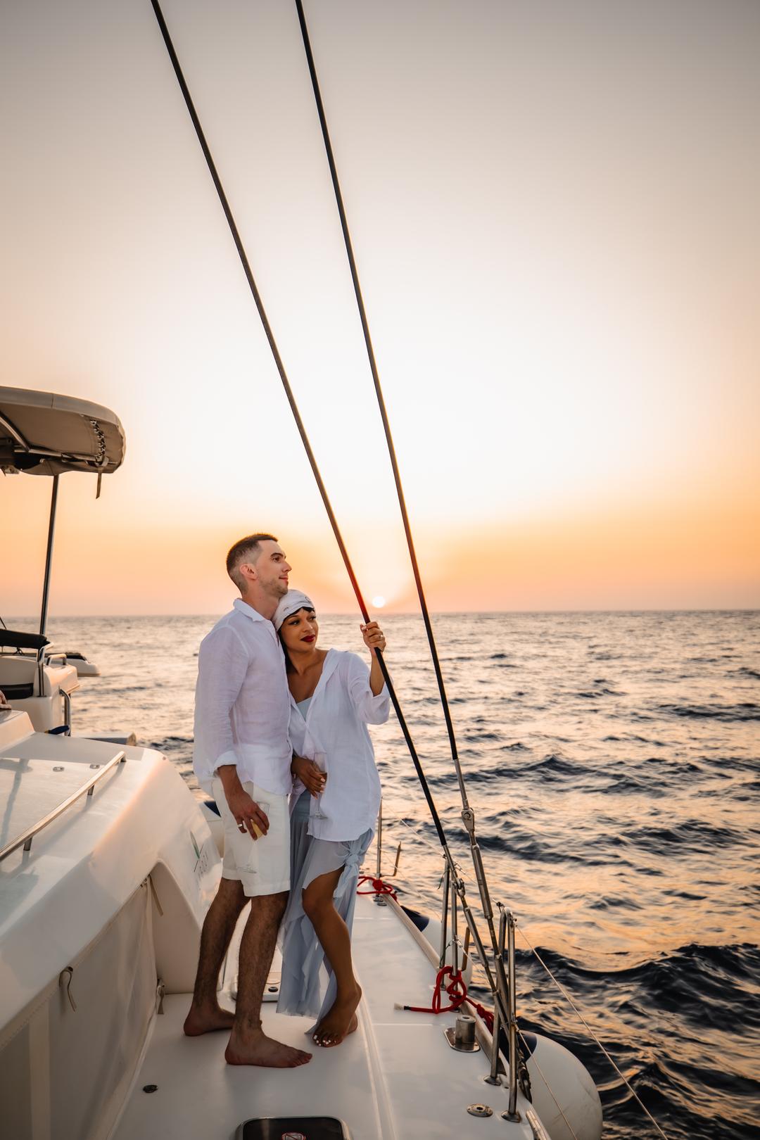 A couple at the bow in golden light on a caldera sail