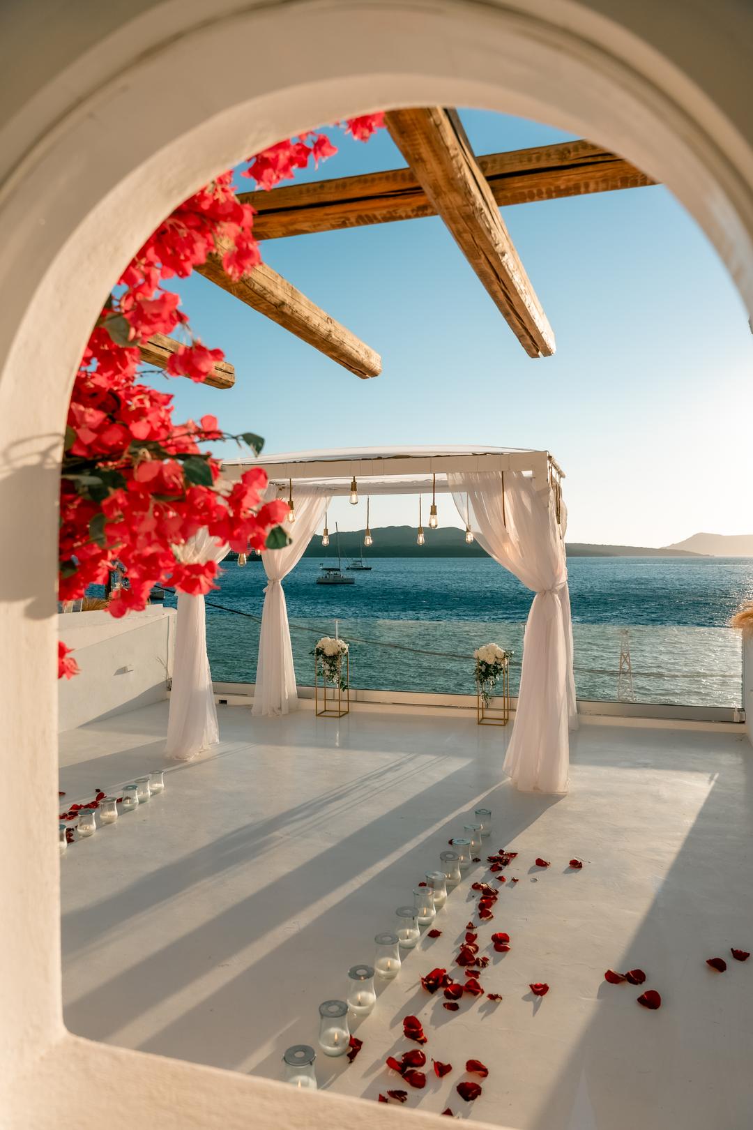 A private terrace styled with a floral pergola at the edge of the Aegean
