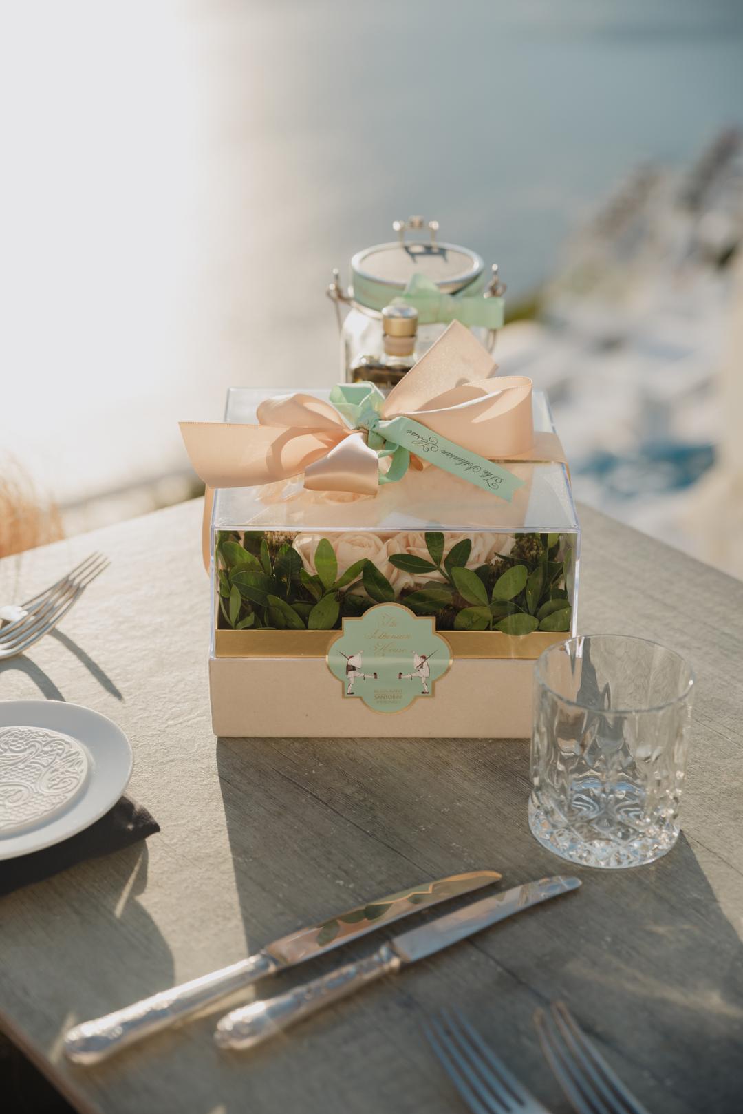 The ring box, safely arrived, waiting beside two glasses on a set table