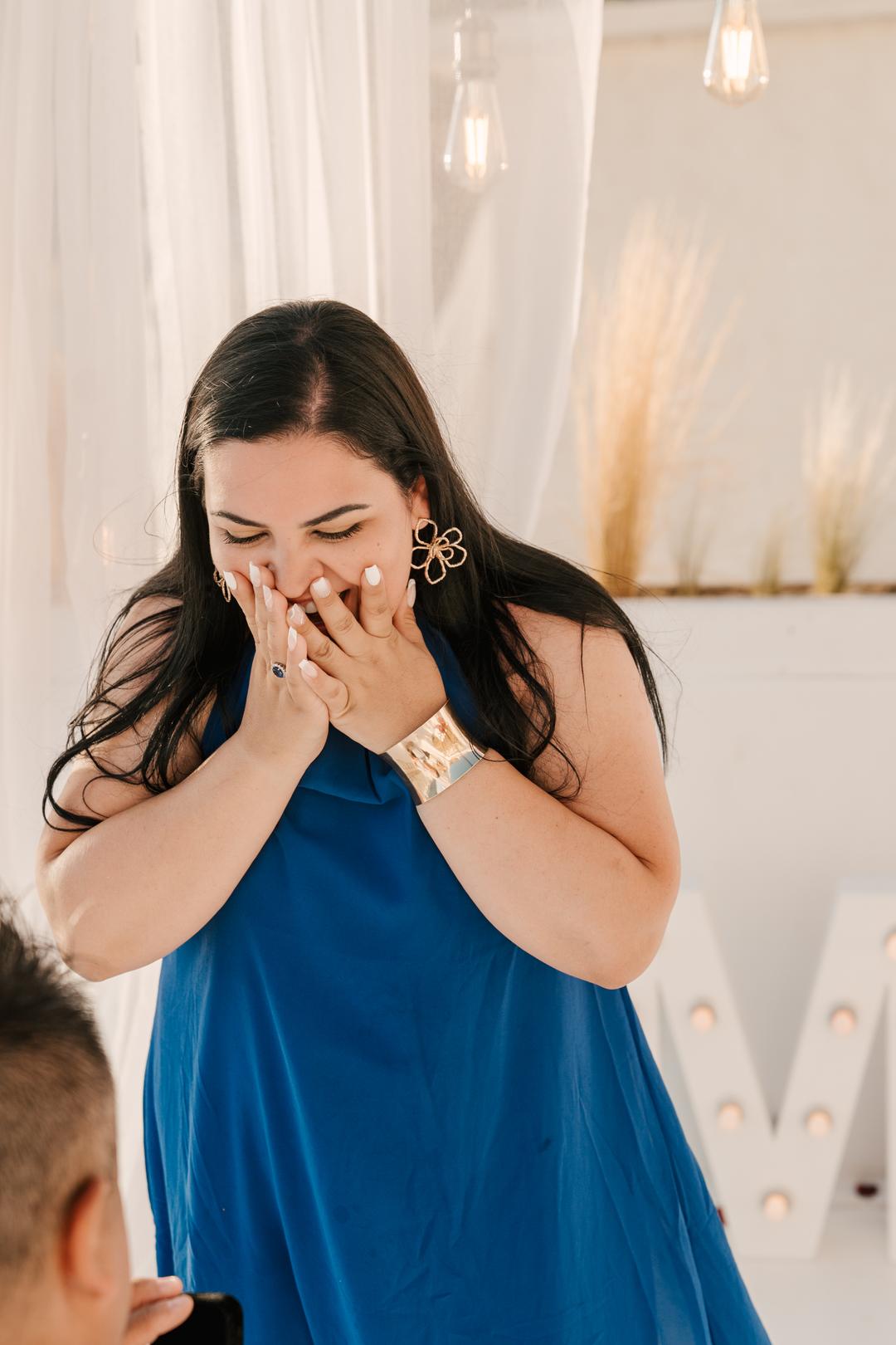 A woman with both hands over her mouth in the seconds after being asked