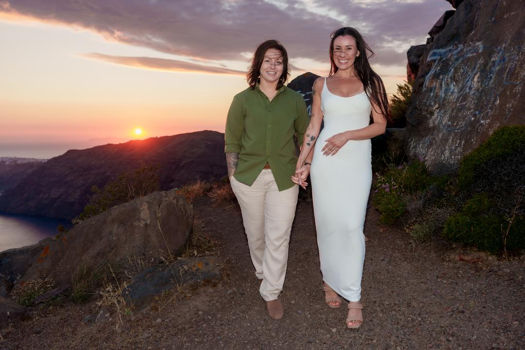 A couple walking together down the rim path as the sun drops behind the far rim