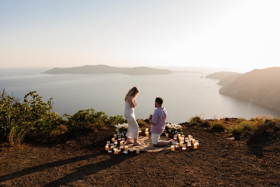 A proposal inside a ring of candles on a quiet ledge, photographed from a distance